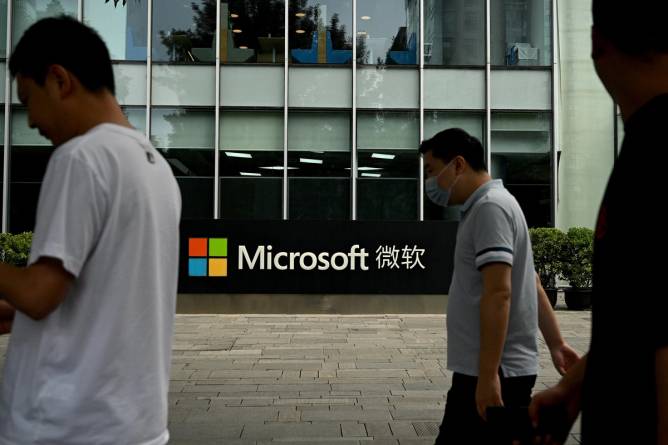 People walking outside a Microsoft building with Chinese characters on the facade.