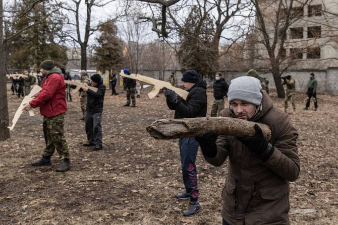 A civilian uses a log as a gun during a military training course conducted by a Christian Territorial Defence Unit on February 19, 2022 in Kyiv, Ukraine. 