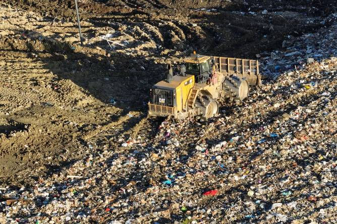 Aerial view of trucks unloading trash into a landfill