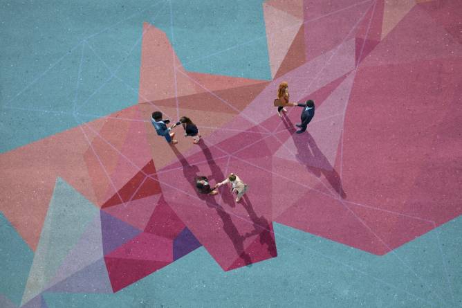 Image of people shaking hands on a multicolored surface.