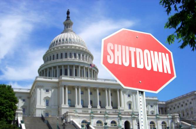 The US Capitol Building with a stop sign in from that says "shutdown"