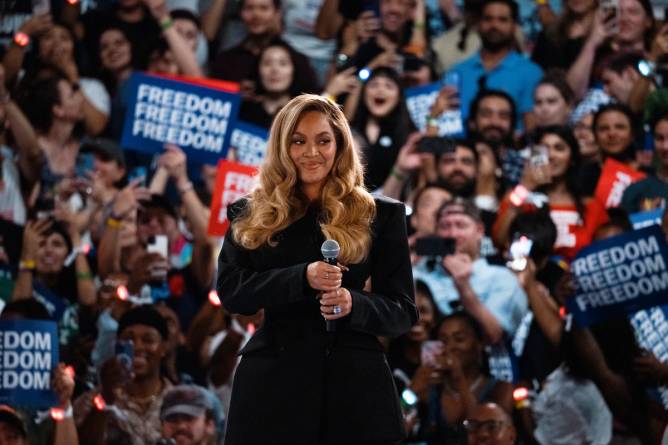 Beyoncé holds a microphone in front of a crowd at a Harris campaign in Houston