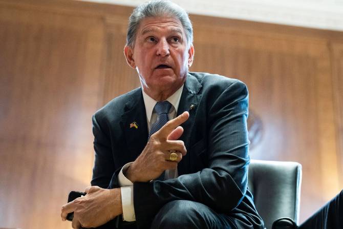 Joe Manchin in a suit pointing.