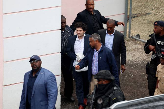Ex-FTX CEO Sam Bankman-Fried being escorted out of court in the Bahamas