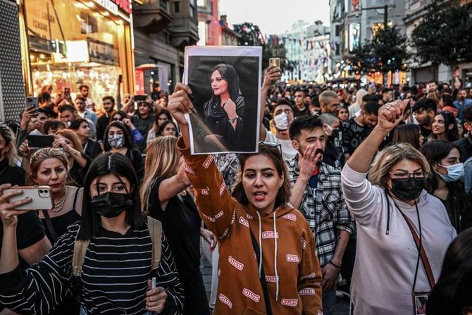 A protester holds a portrait of Mahsa Amini during a demonstration in support of Amini, a young Iranian woman who died after being arrested in Tehran by the Islamic Republic's morality police