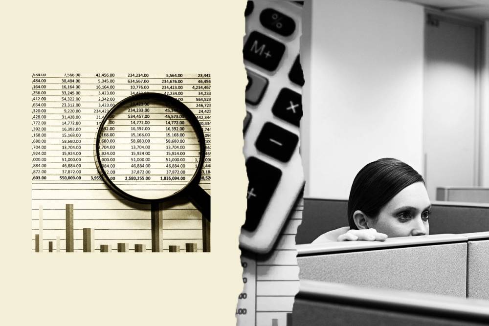 A spreadsheet under a magnifying glass as someone peers over the top of a cubicle.