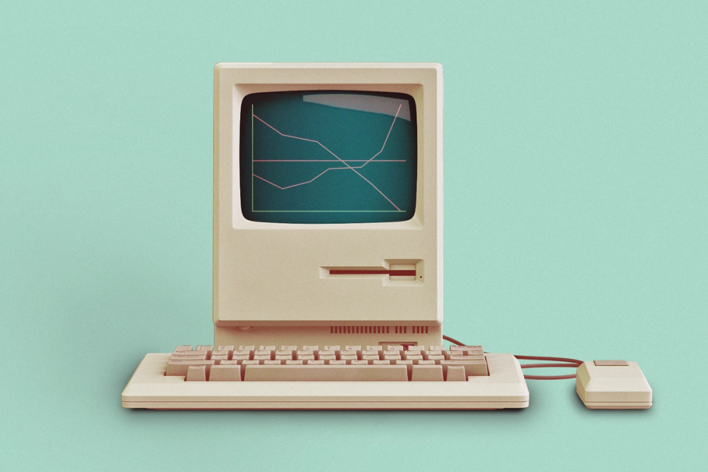 Retro computer with line graph on screen with mouse and keyboard on a light teal background