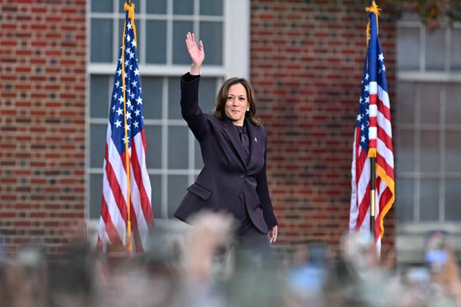 vice president kamala harris waves from a stage