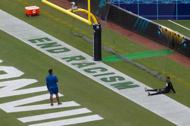 The words End Racism are painted in an end zone on NFL field