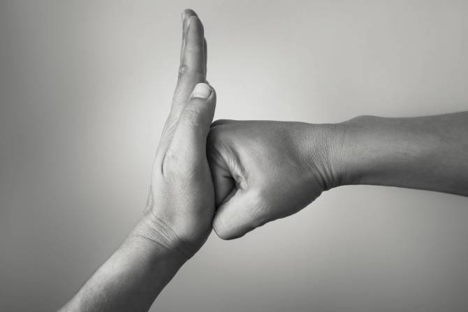 a black and white image of a closed fist going into an open palm