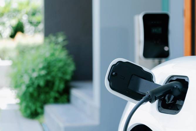 An image of an EV plugged into a home.