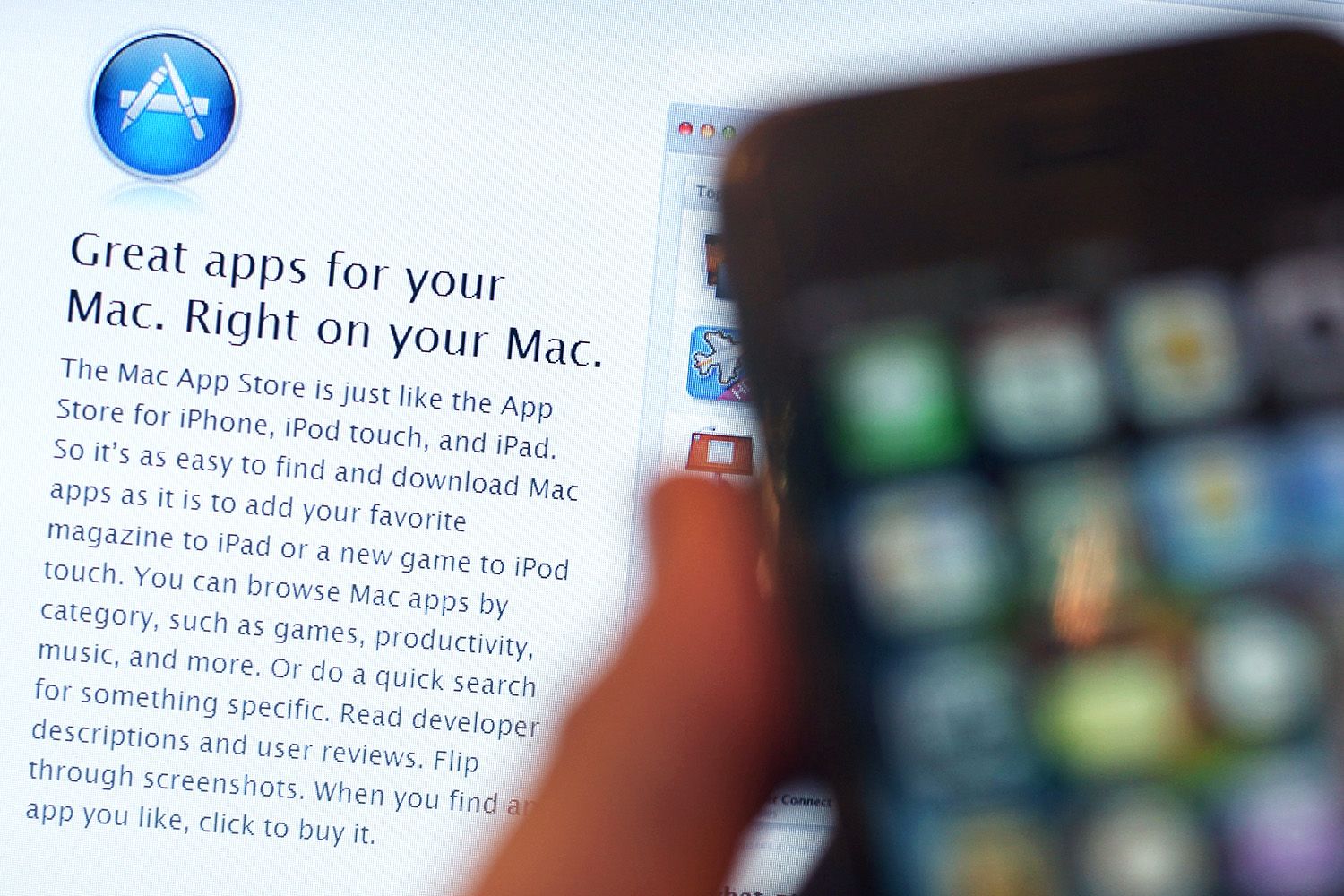 Close crop of iphone screen showing application icons, app store user interface, welcome message