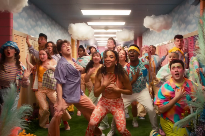 Actors playing high-schoolers dance in colorful clothing in an image from a trailer for the Mean Girls musical