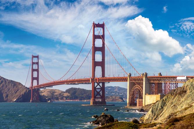 A picture of the Golden Gate bridge against a mostly blue sky with a few white clouds