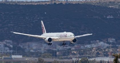 A Qatar Airways airplane taking off during a sunny day