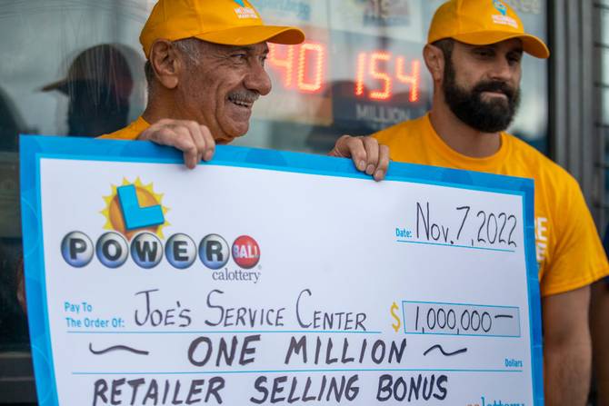 Joe Chahayed, (CH) left, holds up a check for $1,000,000. for the retailer selling bonus and Daniel Chahayed, right, at Joes Service Center on Tuesday, Nov. 8