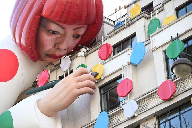 A large inflatable mannequin depicting Japanese contemporary artists Yayoi Kusama decorating the French luxury brand Louis Vuitton flagship store on the Champs-Elysees avenue in Paris.
