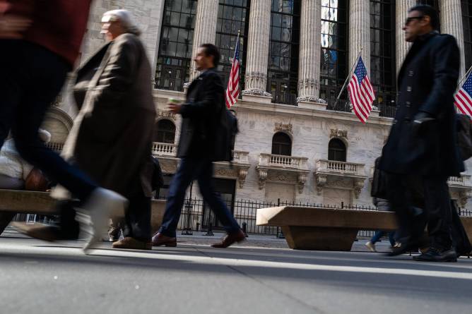 People walk by Wall Street