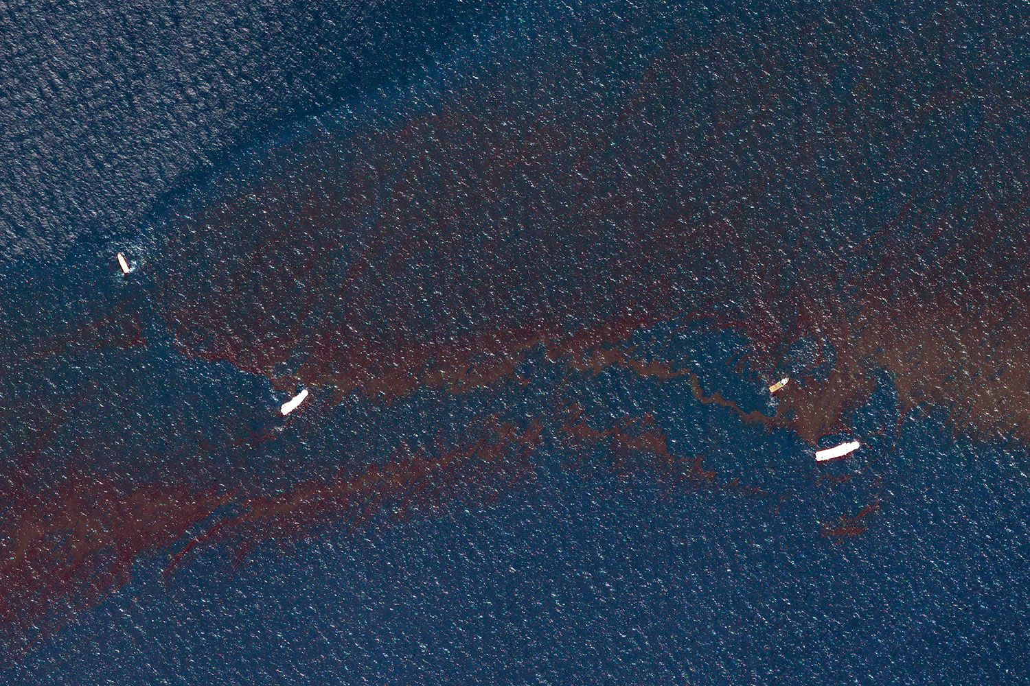 Extreme overhead view of oil spill in ocean, mixing of oil and water