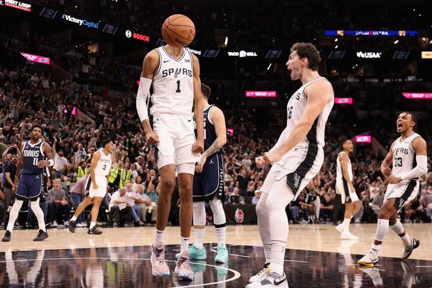 Victor Wembanyama #1 of the San Antonio Spurs celebrates with Cedi Osman #16 after a slam dunk against the Dallas Mavericks