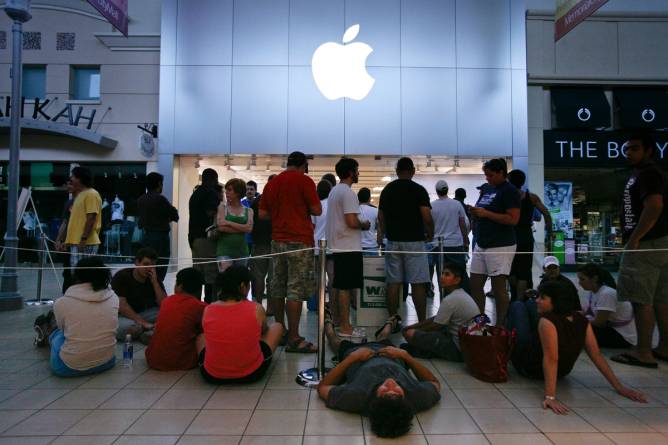 Image of individuals lined up outside an Apple Store.