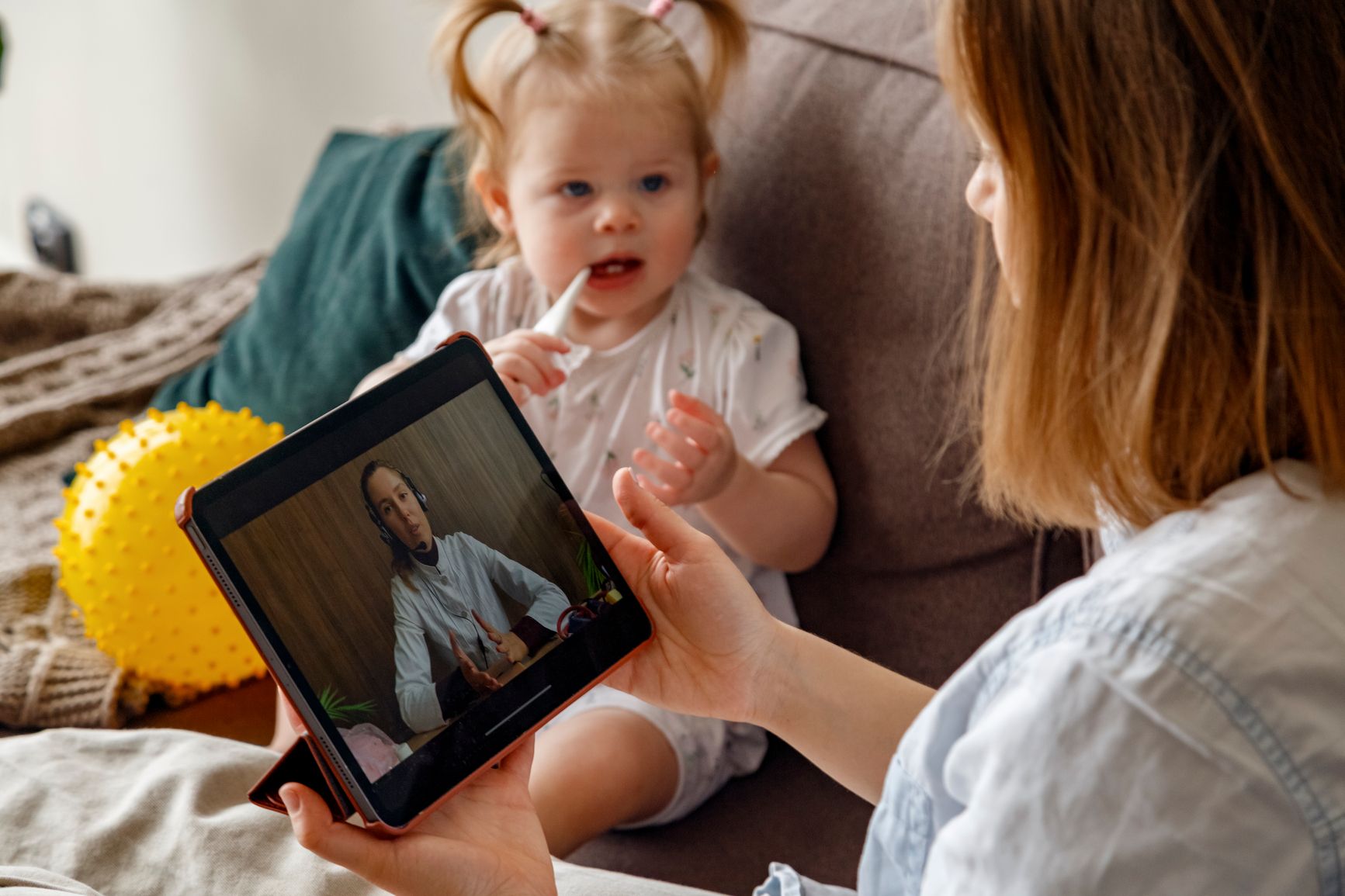 Mother on video call with doctor about sick child.