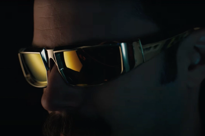 a dark image of a man wearing yellow-tinted sunglasses, in a teaser for a Bud Light Super Bowl ad 