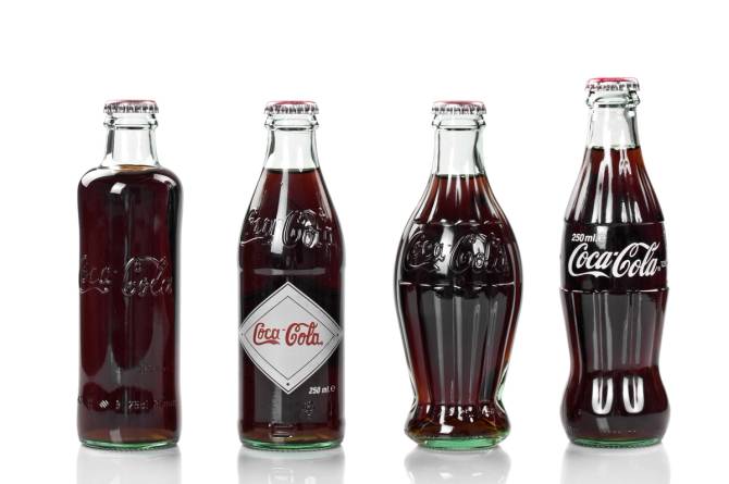 Four Coke bottles, from early versions to the latest version. 