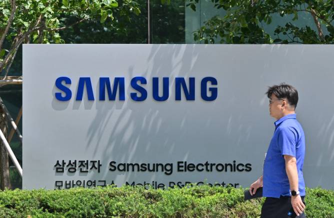 A man walks by a large sign for the Samsung Electronics office in South Korea