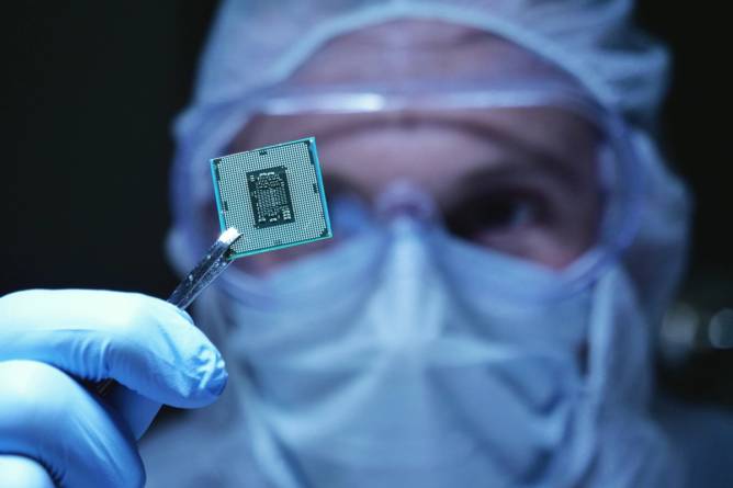 Person in a chip fab holding a microprocessor