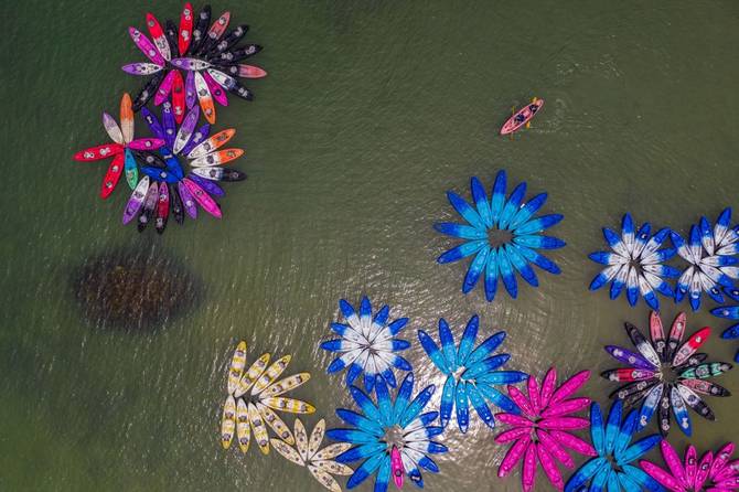 An aerial photo shows people paddling a kayak (top R) in a bay in Hong Kong on June 11, 2023. 