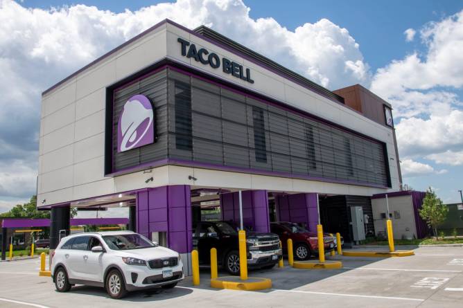 A two-story Taco Bell with multiple drive-thru lanes.