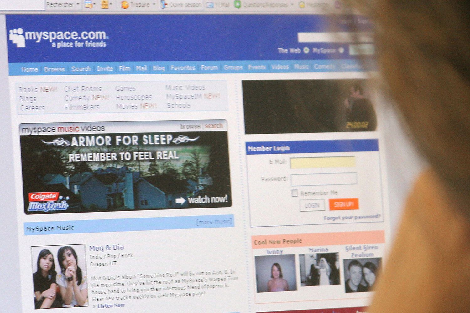 We view a web browser open on a laptop screen. The browser shows an early rendition of Myspace with profile images and a text feed.