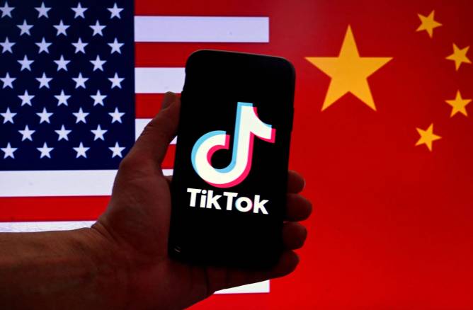 Tiktok logo displayed in front of US, China flags