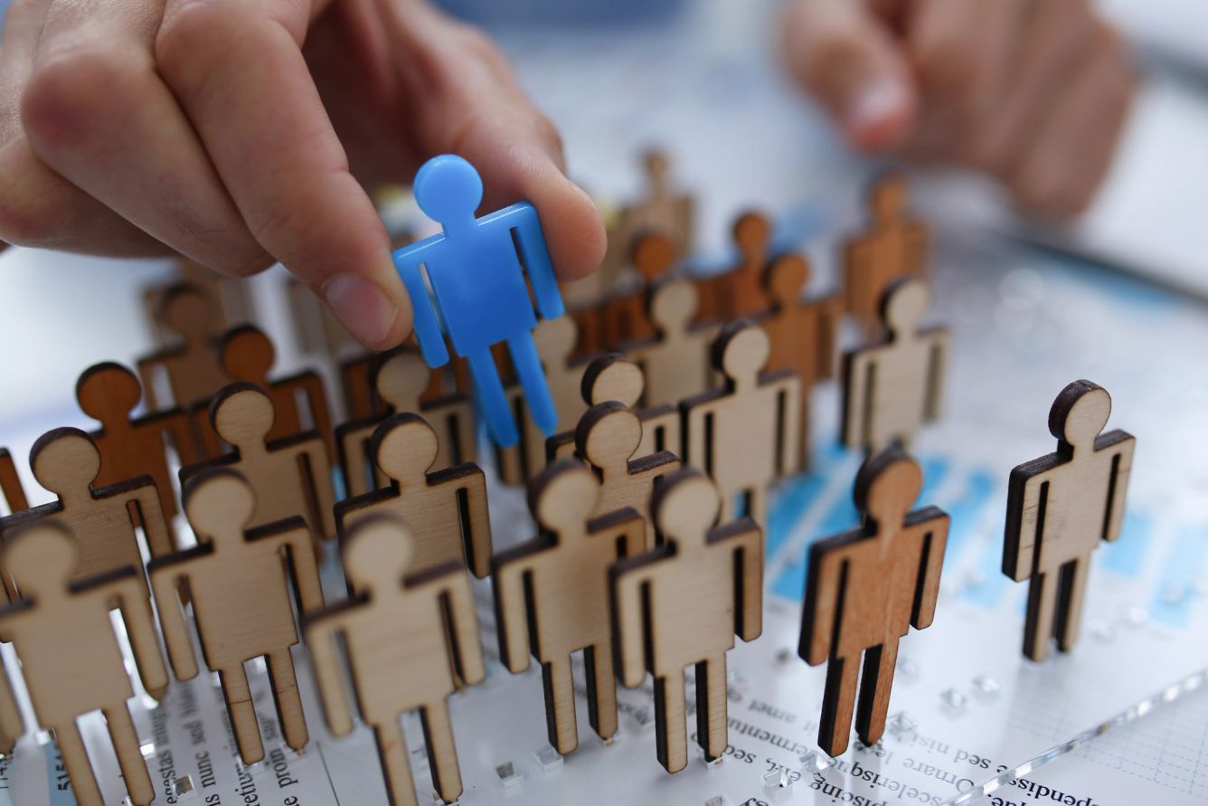 person picking a character from a mass of figures