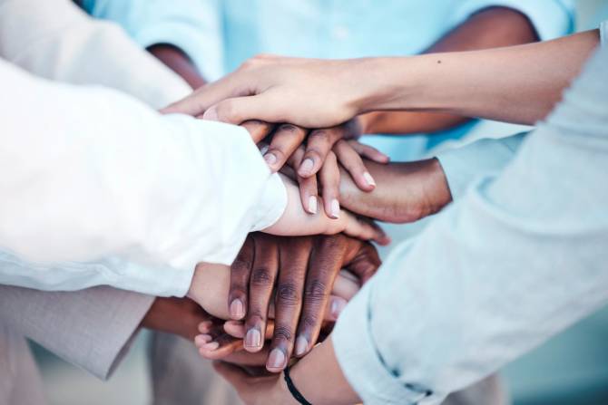 Close-up of hands joining together.