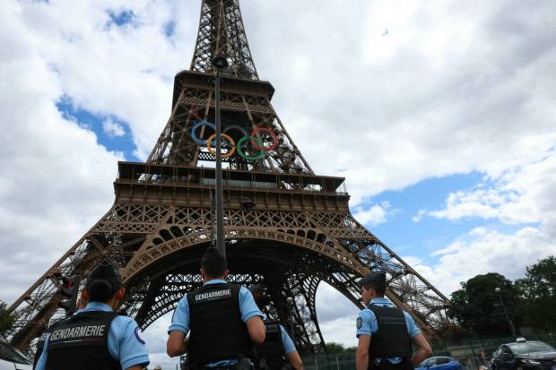 French Gendarmes patrol in front of The Eiffel Tower adorned with The Olympic Rings in the background ahead of the Paris 2024 Olympic and Paralympic Games in Paris on July 16, 2024.