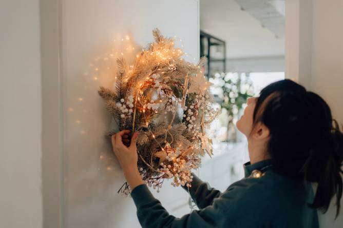 Woman hanging a holiday wreath