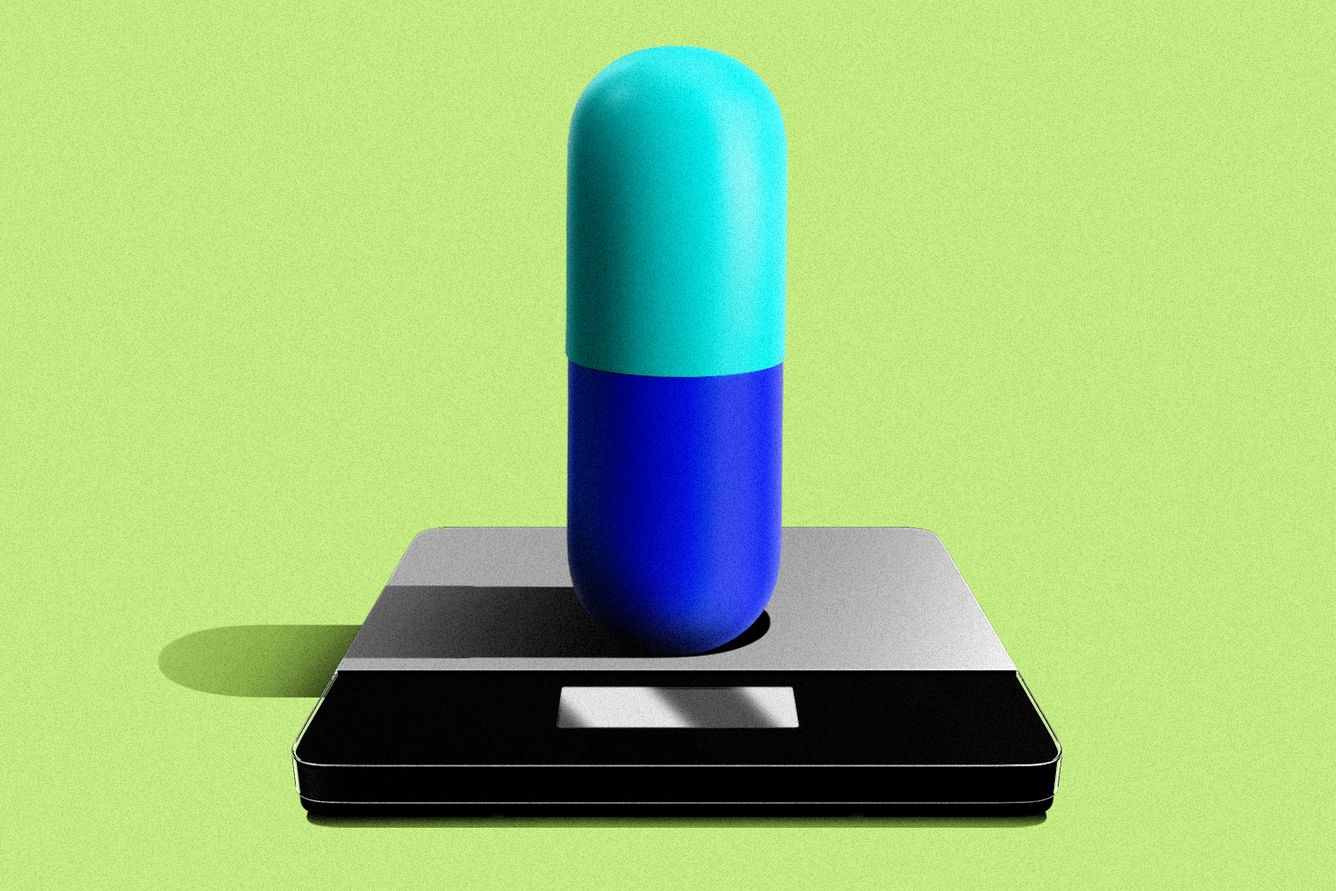 Weight loss pill on a scale