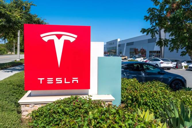 A Tesla sign outside a Tesla delivery center