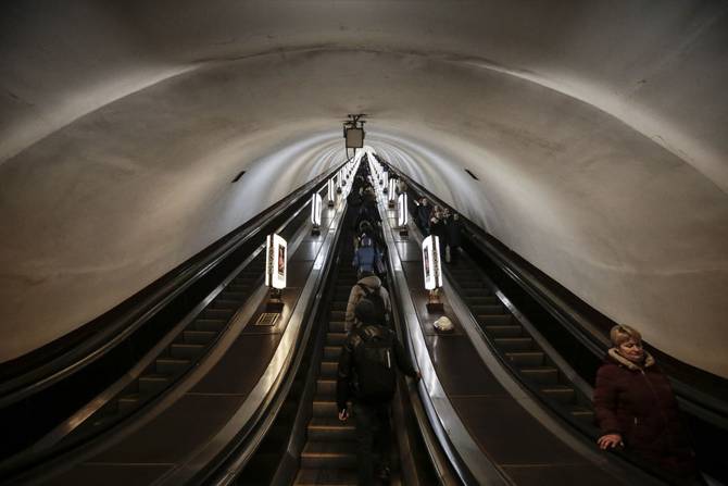 People use escalators inside Arsenalna Station in Kiev, Ukraine