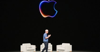 Tim Cook speaking on stage with the Apple logo in the background