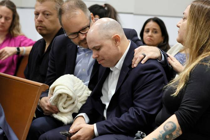 Ryan Petty comforts Ilan Alhadeff as they await the verdict in the trial of Marjory Stoneman Douglas High School shooter Nikolas Cruz at the Broward County Courthouse October 13, 2022 in Fort Lauderdale, Florida