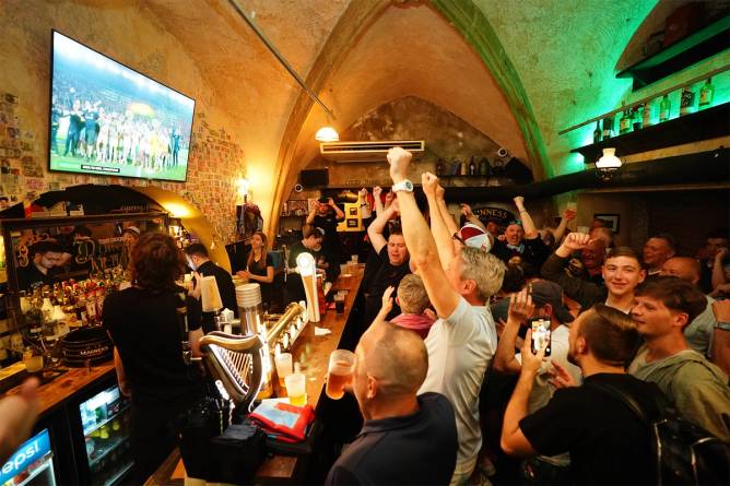 A crowd watching sports in a pub. 