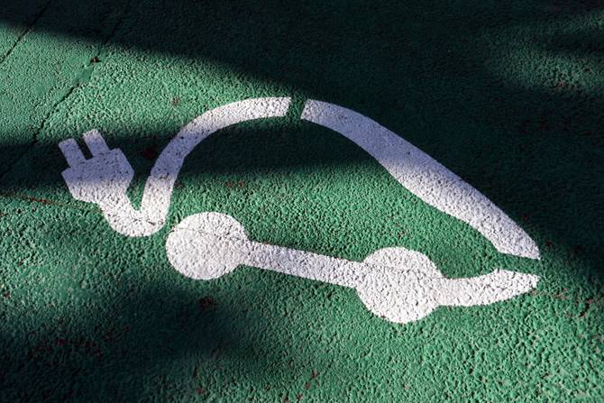 electric vehicle illustration painted on a parking spot in white paint