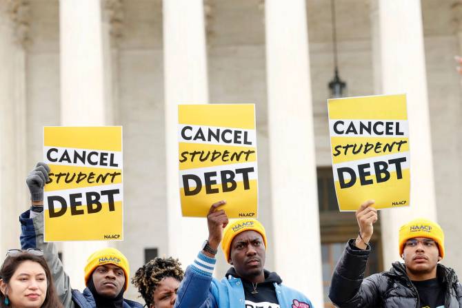 People holding up Cancel Student Debt signs in front of the Supreme Court