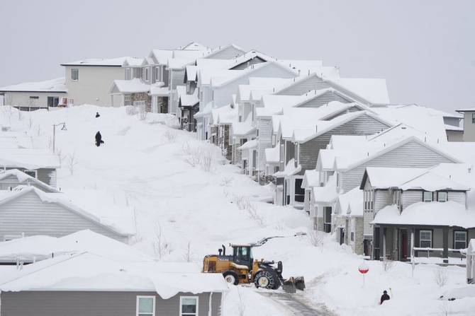 A front end loader removes snow from a residential street in Draper, Utah, on February 23, 2023.