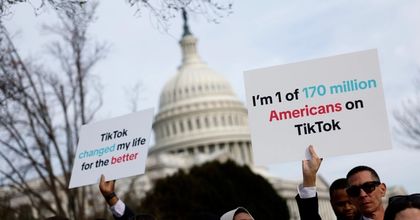 Protestors holding up signs supporting TikTok in front of the US Capital building