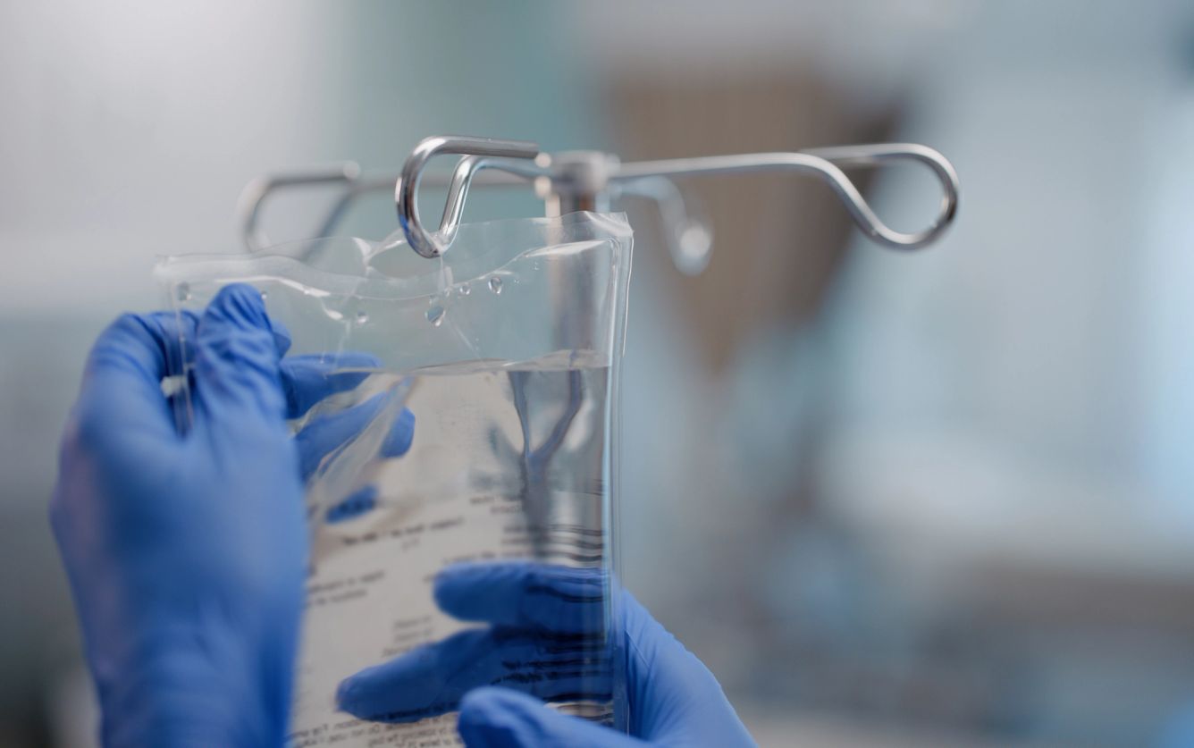 Hand putting up an IV bag