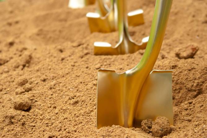 Golden shovels dig into dirt